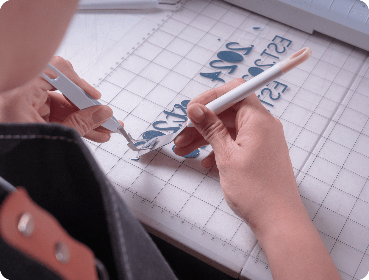 Person crafting with cutting tools on grid.