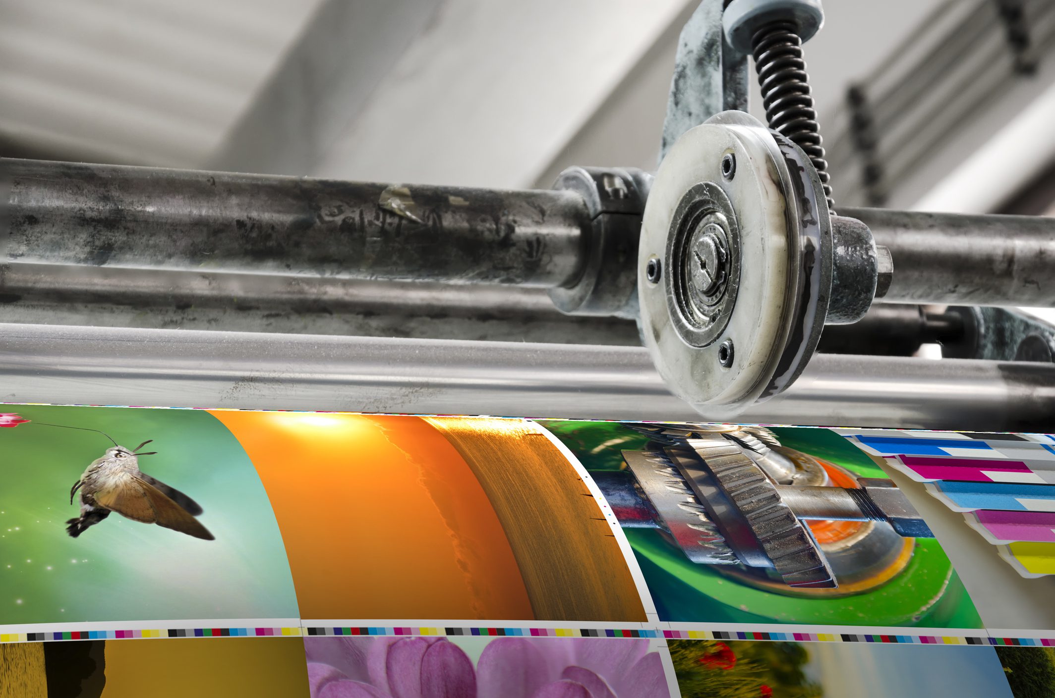Printing press with colorful images on paper.
